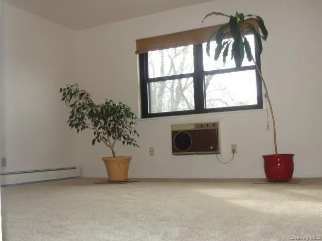 a view of empty room with chandelier fan and refrigerator