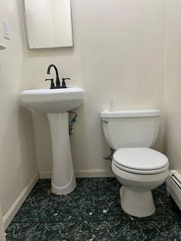a bathroom with a toilet sink and mirror