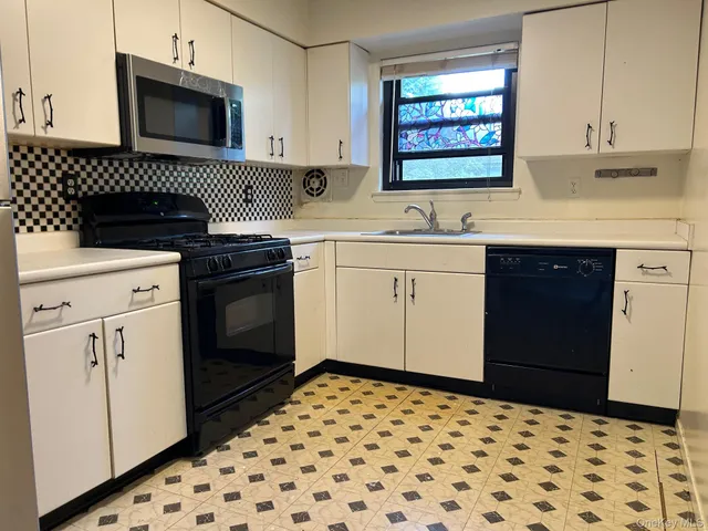 a kitchen with a sink a stove and cabinets