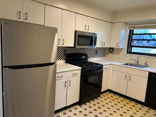 a kitchen with stainless steel appliances a refrigerator sink and cabinets