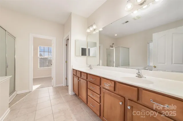 a spacious bathroom with a double vanity sink and a mirror