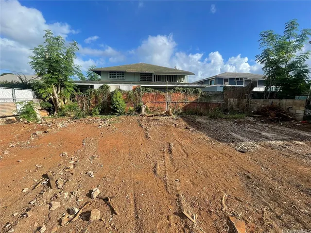 a view of a patio with table and chairs under an umbrella with large trees