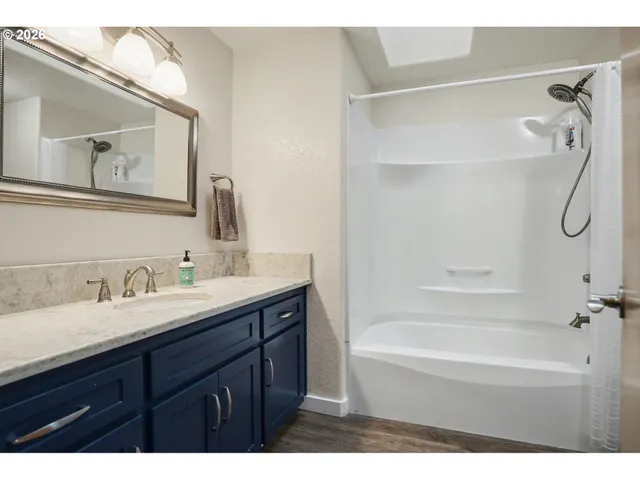 a bathroom with a tub sink and mirror
