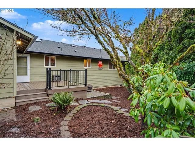 a view of a house with a small yard and floor to ceiling window and potted plants