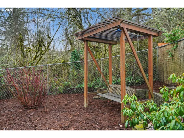a view of a backyard with plants and wooden fence