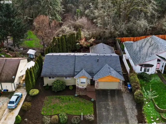 an aerial view of a house with a big yard and large trees