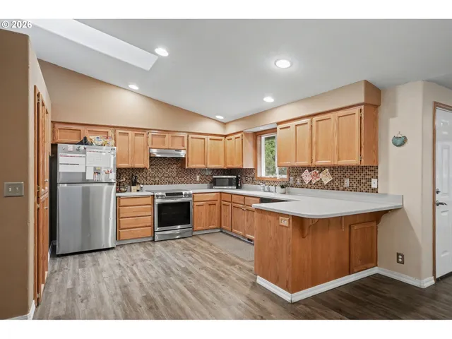 a kitchen with stainless steel appliances granite countertop a stove a sink dishwasher and a refrigerator