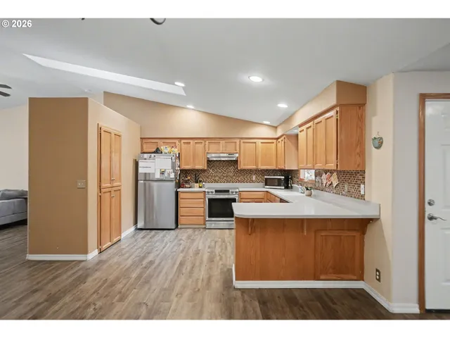 a kitchen with kitchen island a sink appliances and cabinets