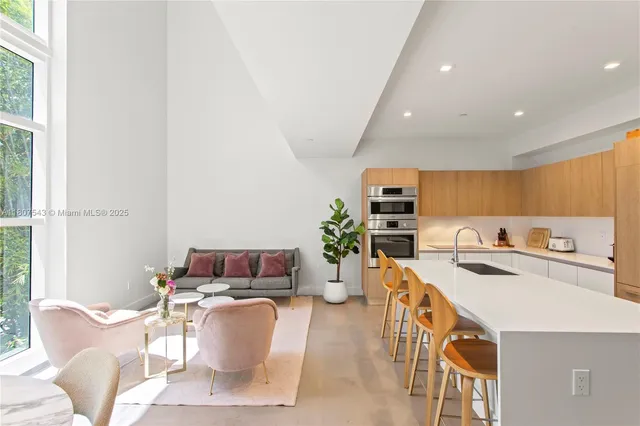 a living room with furniture a flat screen tv and a window