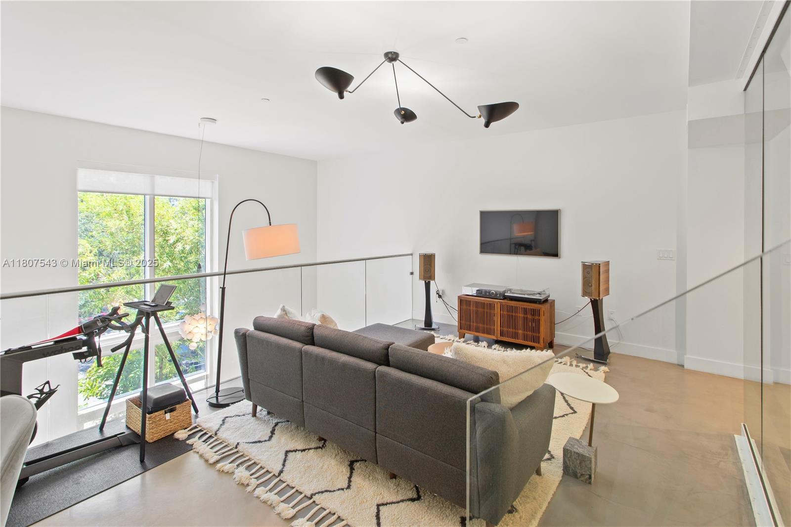 455 Northeast 39th Street, Unit 102 Miami, FL 33137 - Photo 15 of 32 a living room with furniture a flat screen tv and a large window