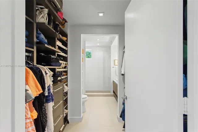 a view of walk in closet with clothes and shoes