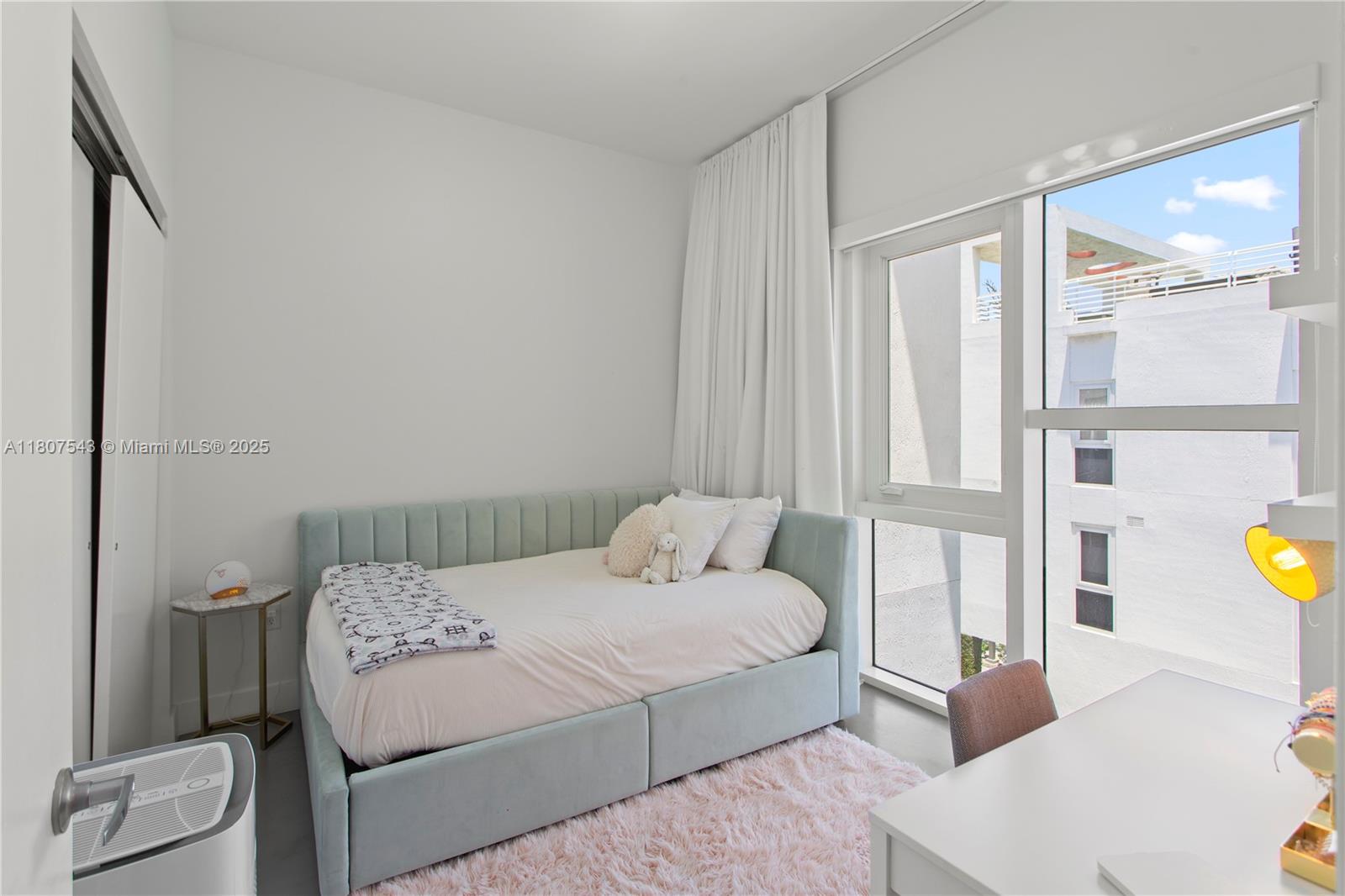 455 Northeast 39th Street, Unit 102 Miami, FL 33137 - Photo 21 of 32 a bedroom with a bed and painting on the wall