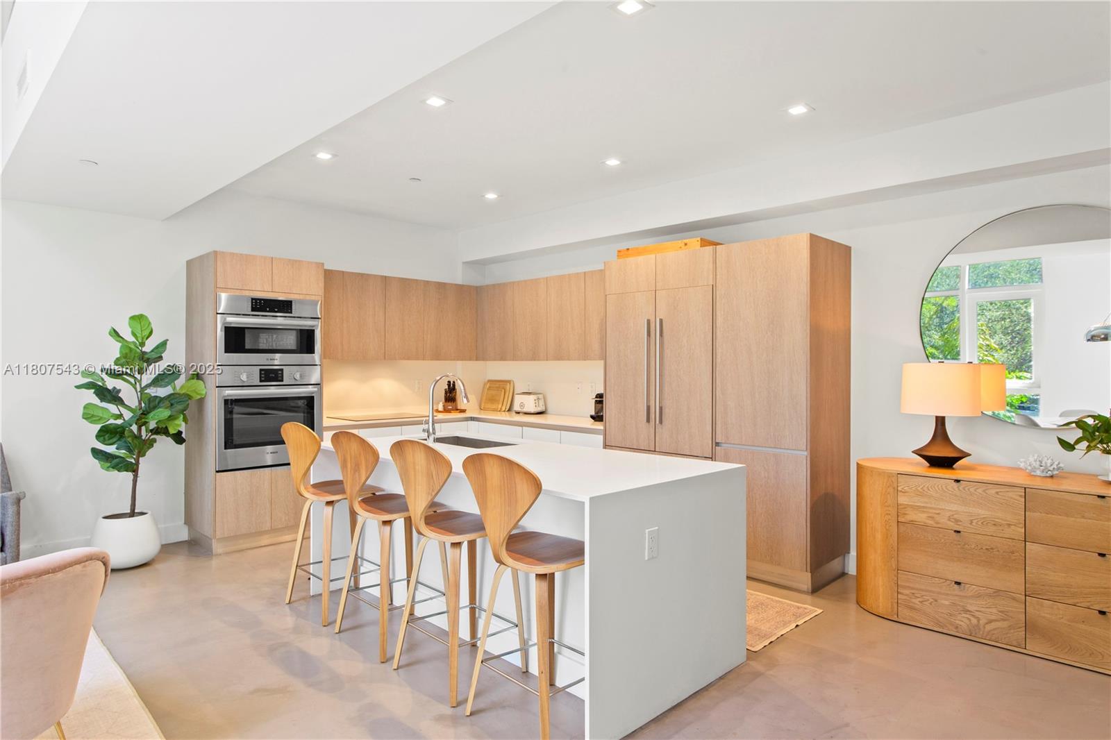 455 Northeast 39th Street, Unit 102 Miami, FL 33137 - Photo 4 of 32 a view of a kitchen with kitchen island white cabinets and stainless steel appliances