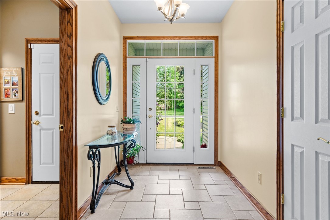 7644 Morley Road Mentor, OH 44060 - Photo 6 of 50 Tiled light-filled Foyer with chandelier and coat closet. Mudroom with access to 2-car side entry garage is visible in this photo