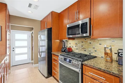 a kitchen with stainless steel appliances granite countertop a stove and a microwave