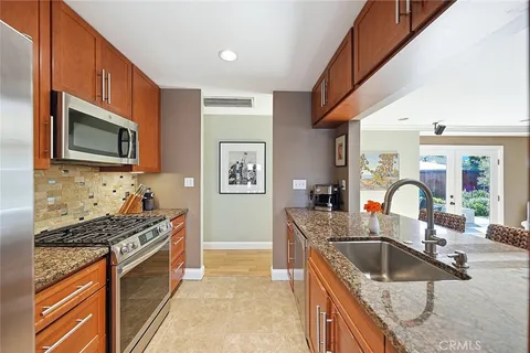 a kitchen with stainless steel appliances granite countertop a sink stove and refrigerator