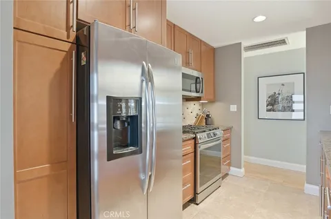 a kitchen with stainless steel appliances granite countertop a refrigerator and a stove