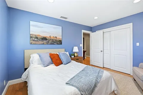 a bedroom with bed and wooden floor