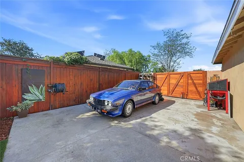 a car parked in front of a house with wooden fence
