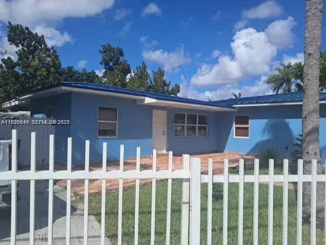 a view of a brick house with a flower garden in the background