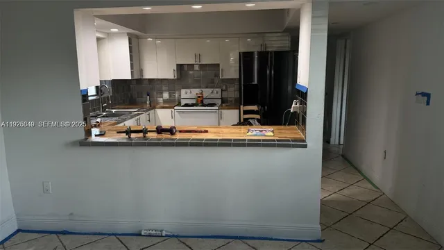 a view of a kitchen with stainless steel appliances granite countertop a refrigerator and a counter space