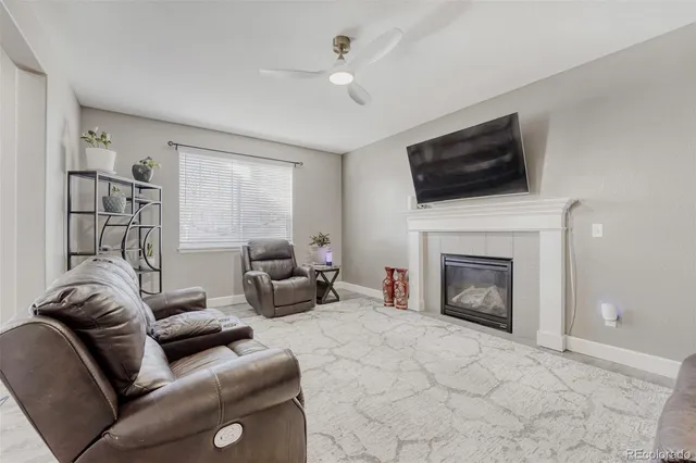a living room with furniture a flat screen tv and a fireplace