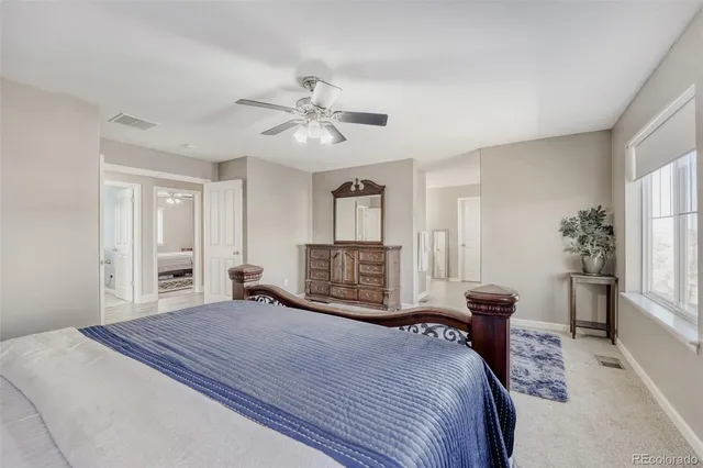 a bedroom with a large bed a chandelier and a window