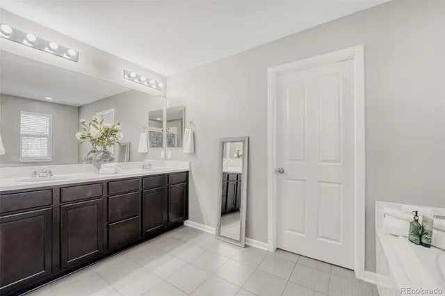 a spacious bathroom with a double vanity sink and a mirror