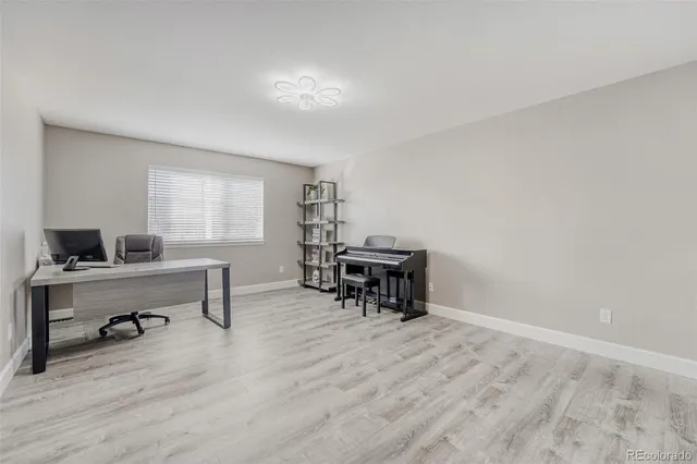 a view of a workspace with furniture and a window