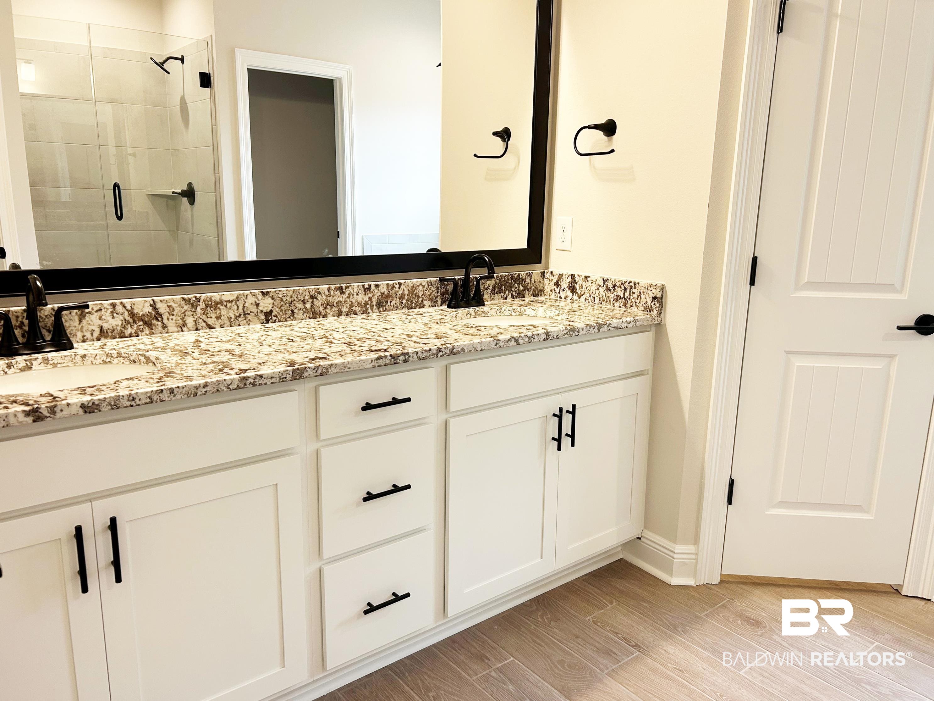 873 Sumter Loop Foley, AL 36535 - Photo 14 of 26 Full bath with double vanity, a stall shower, and wood tiled floors