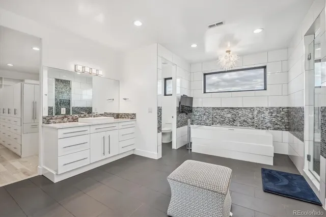 a bathroom with a granite countertop sink a toilet a mirror and bathtub