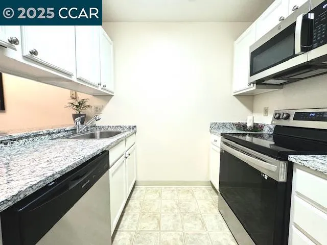 a kitchen with stainless steel appliances granite countertop a sink and a stove
