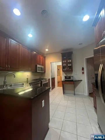 a kitchen with stainless steel appliances granite countertop a sink counter space and cabinets
