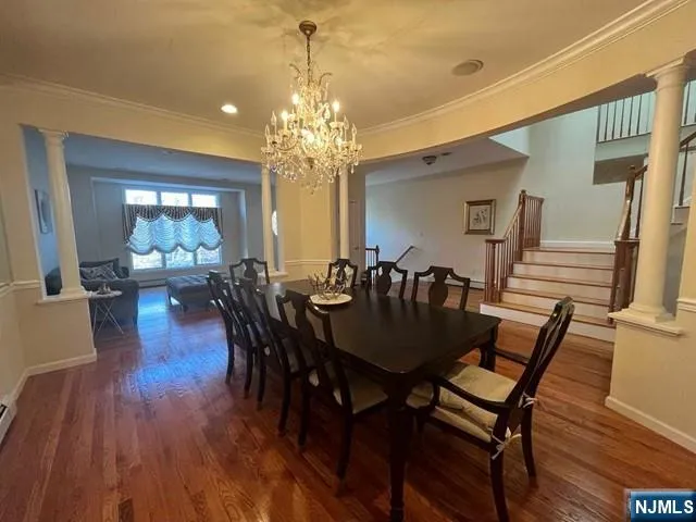 a view of a a dining room with furniture wooden floor and chandelier