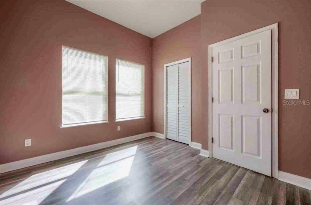 2322 West Cherry Street Tampa, FL 33607 - Photo 10 of 31 an empty room with wooden floor and windows