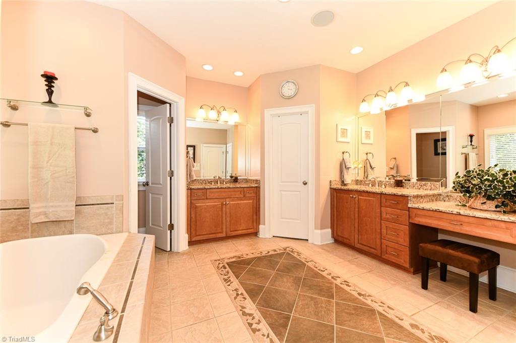 6021 Beckenham Way Oak Ridge, NC 27310 - Photo 15 of 44 Arched doorways on the kitchen sides on tile with a tiled back splash and granite tops. The SS appliances include an oven and build in microwave. Counter lip is great for company to sit on the barstools and chat.