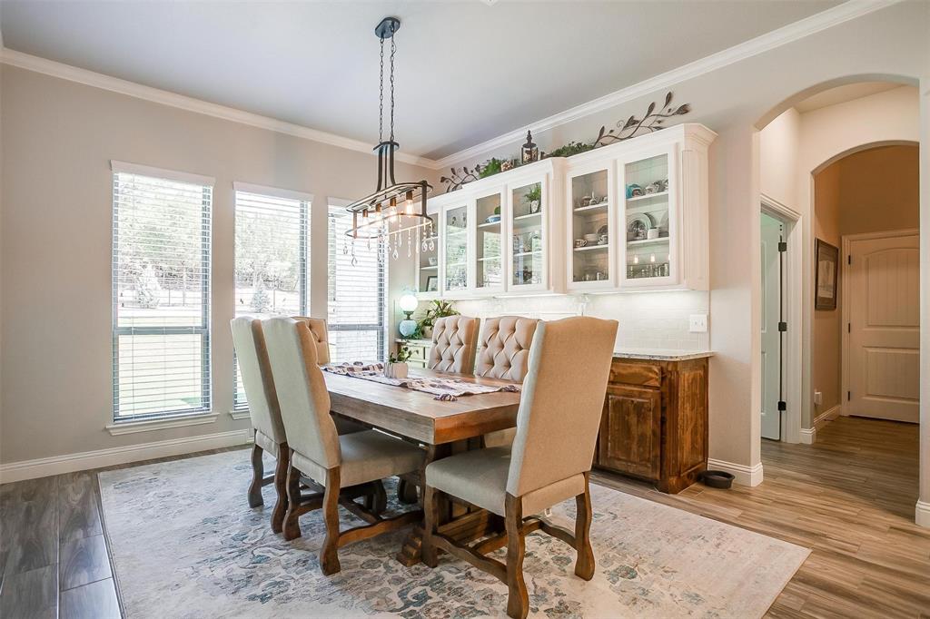 409 Glade Crest Road Azle, TX 76020 - Photo 11 of 31 a dining room with furniture a chandelier and wooden floor