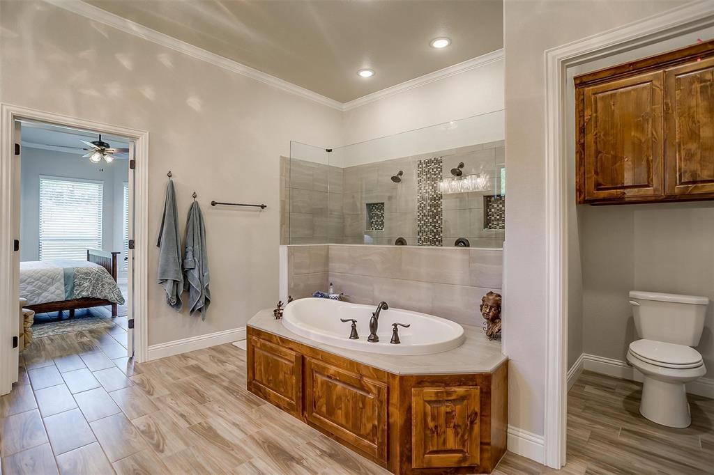 409 Glade Crest Road Azle, TX 76020 - Photo 15 of 31 a bathroom with a bathtub and a toilet