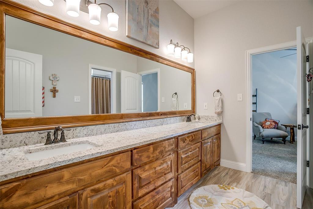 409 Glade Crest Road Azle, TX 76020 - Photo 22 of 31 a bathroom with a granite countertop double vanity sink and a mirror