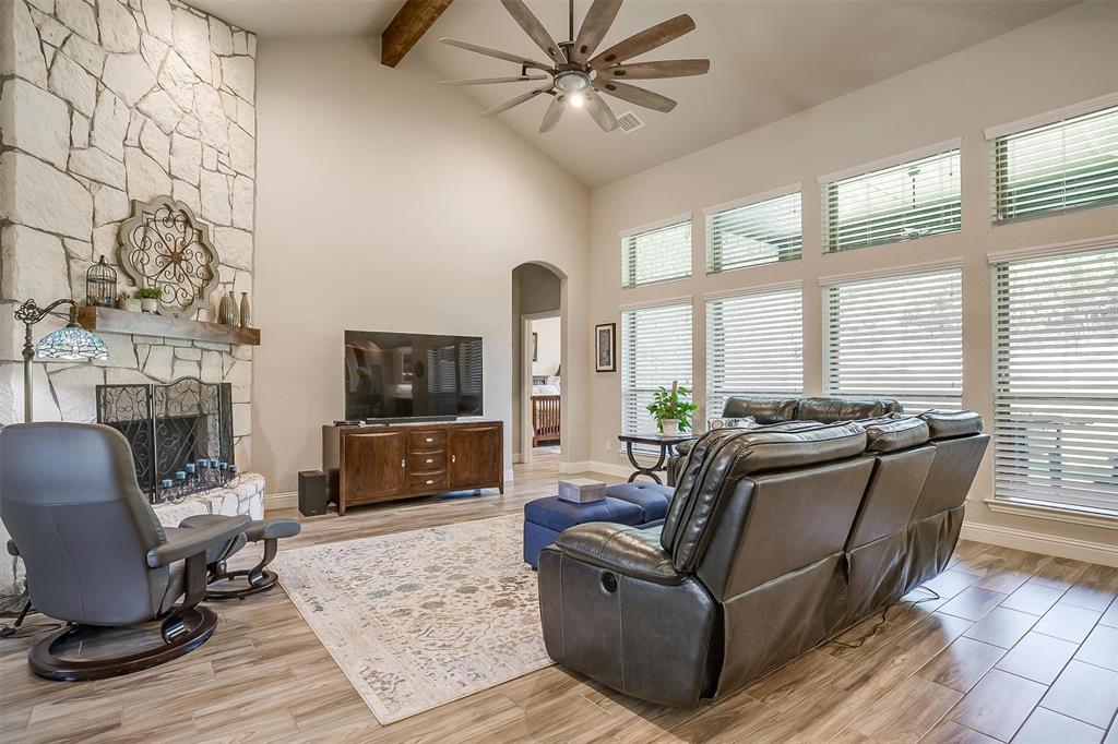 409 Glade Crest Road Azle, TX 76020 - Photo 4 of 31 a living room with furniture a flat screen tv and a fireplace