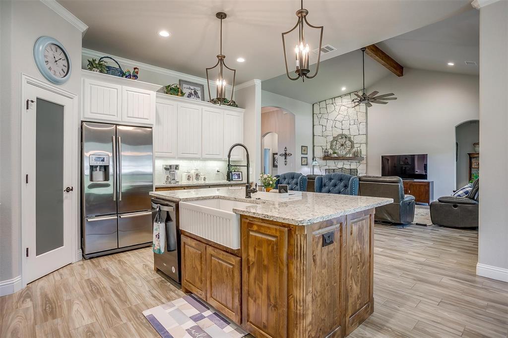 409 Glade Crest Road Azle, TX 76020 - Photo 6 of 31 a kitchen with stainless steel appliances granite countertop a sink a stove and a refrigerator