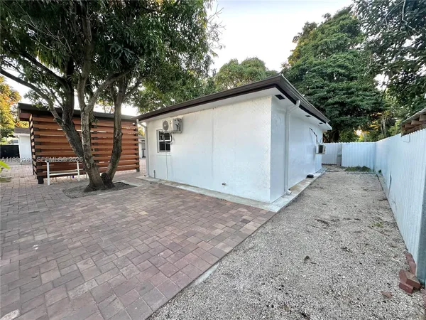 a view of backyard with wooden fence and large trees