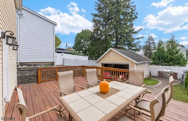 a view of a patio with table and chairs with wooden floor and fence