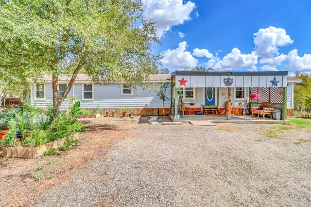 a view of a house with a yard and potted plants
