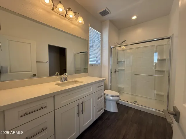 a bathroom with a sink a toilet and shower