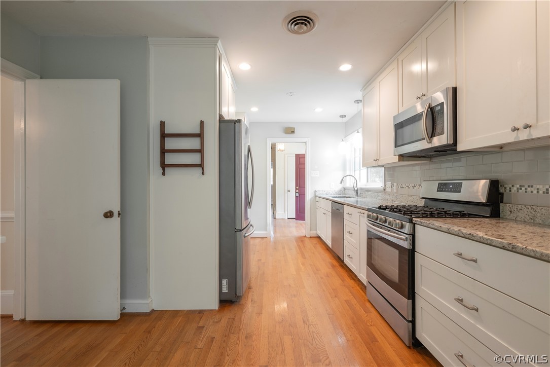 8401 Halesworth Road Richmond, VA 23235 - Photo 25 of 50 a large kitchen with stainless steel appliances granite countertop a refrigerator a stove and a wooden floors