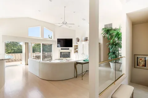 a living room with furniture and a large window with wooden floor