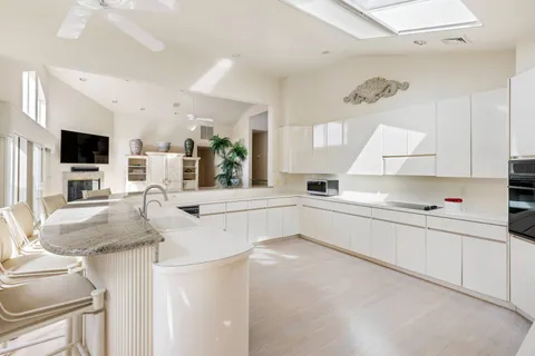 a kitchen with stainless steel appliances kitchen island granite countertop a sink and cabinets