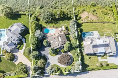 an aerial view of residential houses with outdoor space and lake view