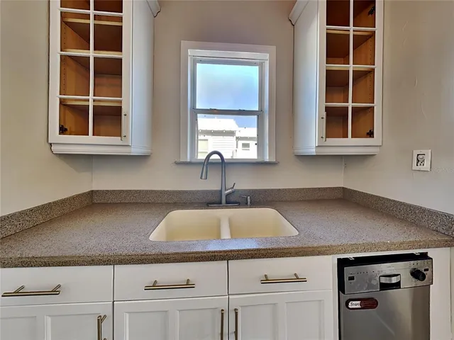 a kitchen with granite countertop a sink and cabinets
